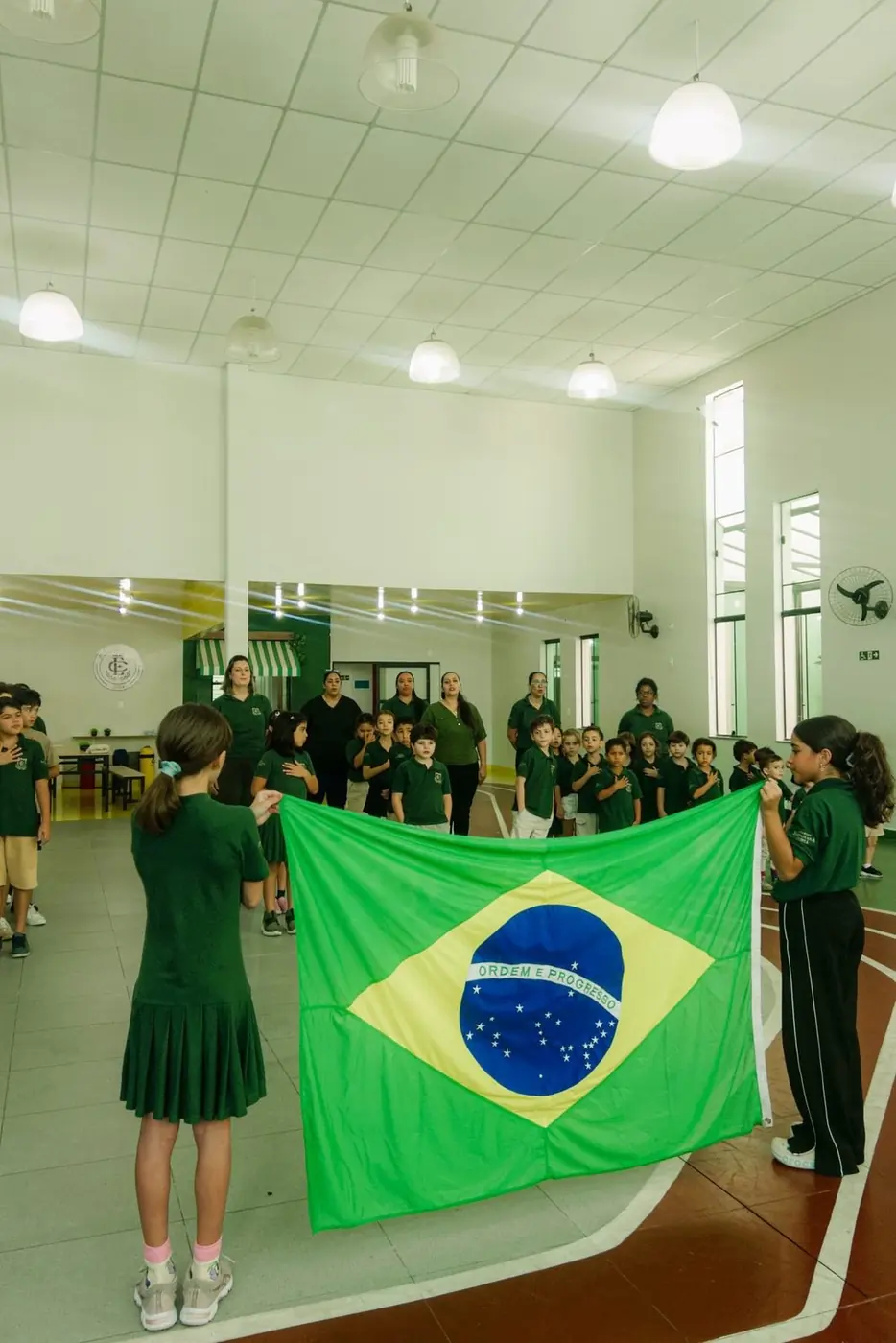 Alunos com a bandeira do Brasil no ato cívico
