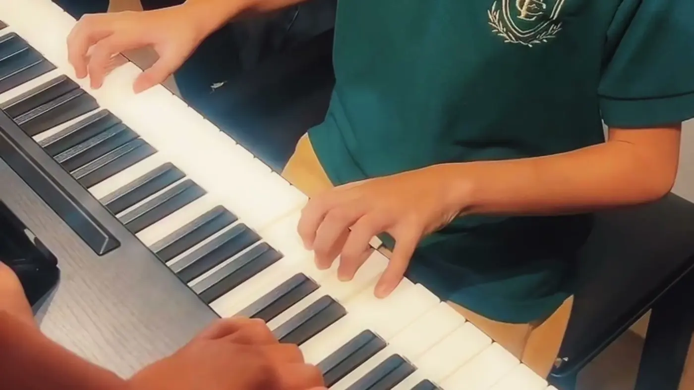 Aluno tocando teclado na aula de música