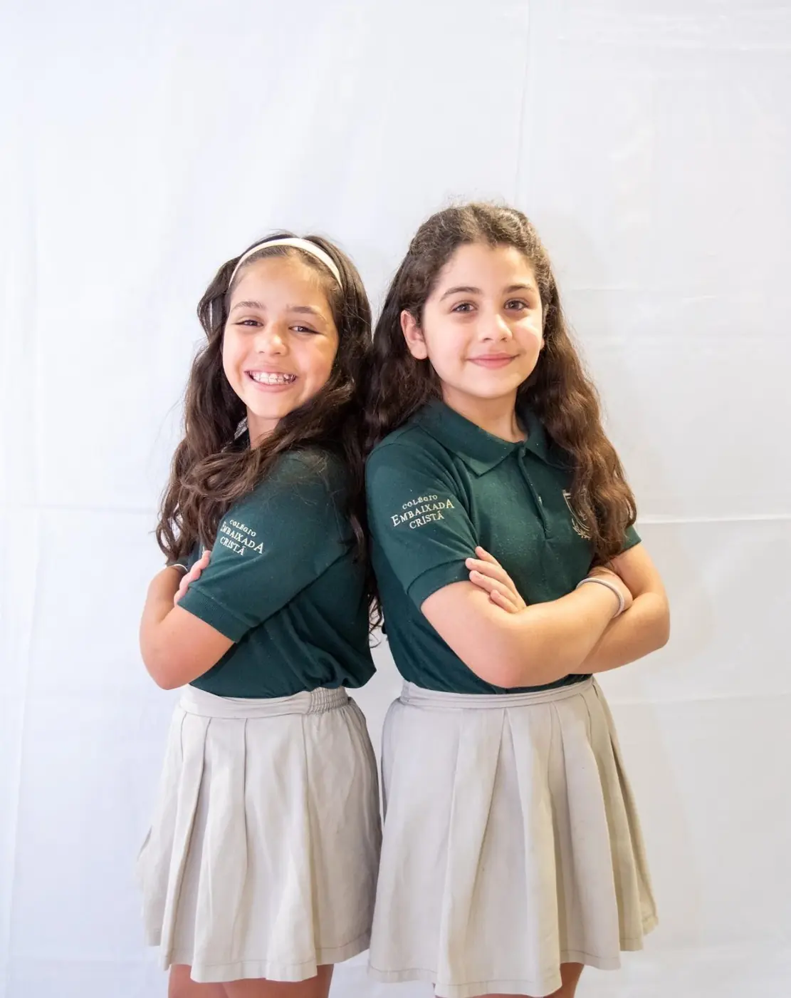 Duas alunas sorrindo com o uniforme do colégio