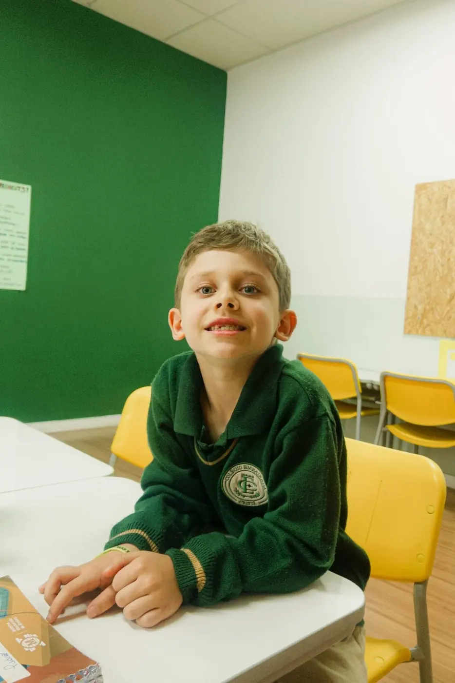 Aluno do Fundamental I sorrindo na carteira